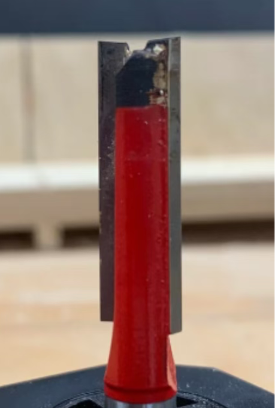 Router bit chipping shown as a blackened and damaged cutter tip